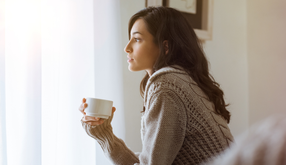 woman drinking coffee looking sad